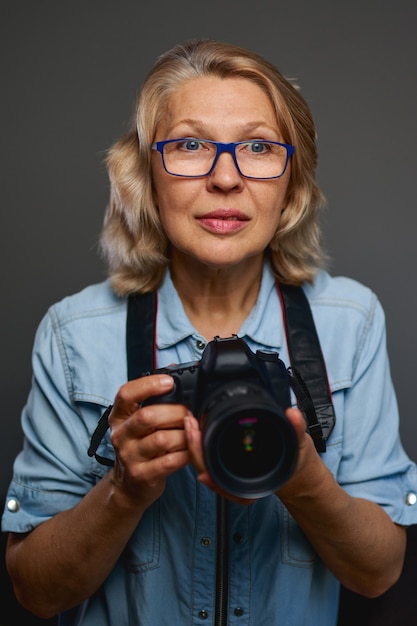 Starsza kobieta fotograf robi zdjęcia aparatem dslr