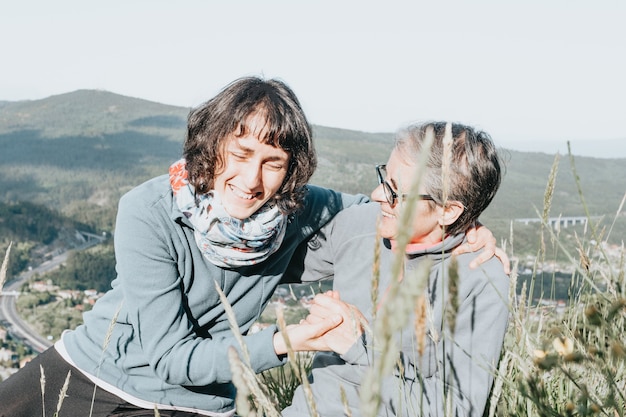 Starsza kobieta i jej córka uśmiechają się i bawią w lesie podczas szczęśliwego dnia matki mother