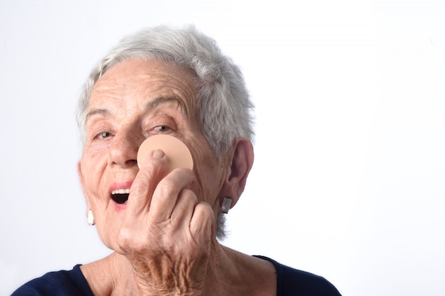 Starsza kobieta makijażu twarz na białym tle