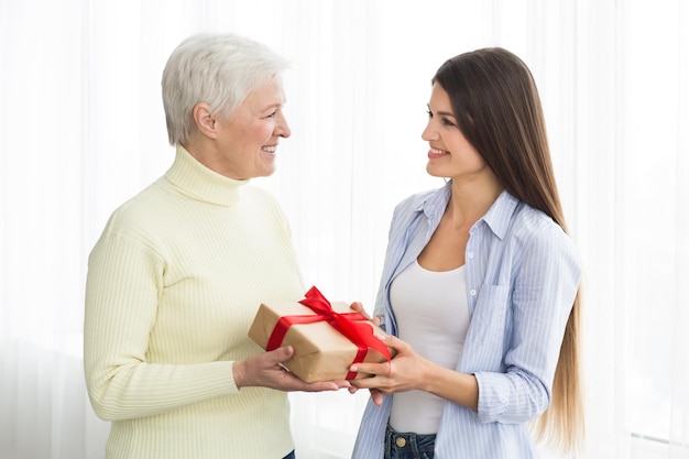 Starsza kobieta otrzymująca prezent od dorosłej córki