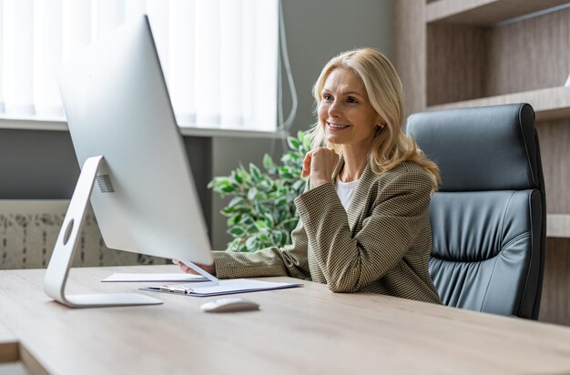 Starsza kobieta pracująca przy komputerze online koncepcje dotyczące biznesu i technologii