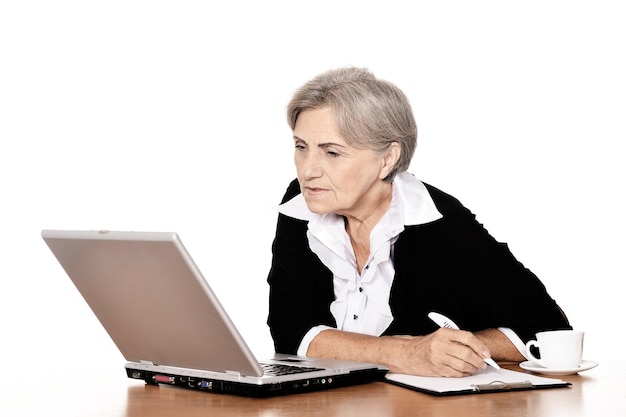 starsza kobieta pracująca z laptopem na białym tle