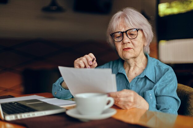 starsza kobieta pracuje przed monitor laptopa posiedzenia Kobieta na czacie na emeryturze bez zmian. Zdjęcie wysokiej jakości