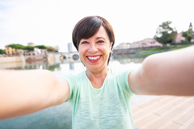 Starsza kobieta robi selfie portret robi fitness na świeżym powietrzu