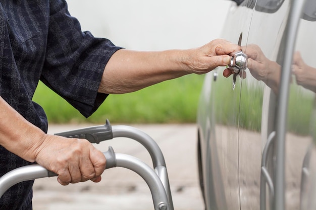 Starsza kobieta używa chodzika na parkingu