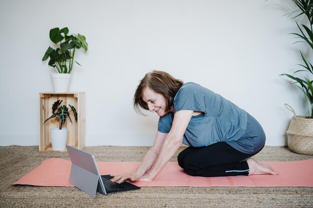 Starsza kobieta używająca laptopa w domu
