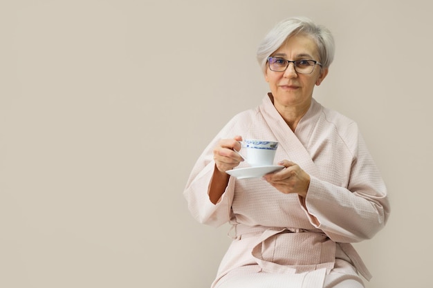 starsza kobieta w szlafroku z filiżanką herbaty