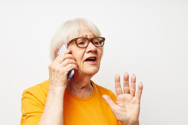 Starsza kobieta w zwykłych okularach tshirt rozmawia przez telefon emocje zbliżenia