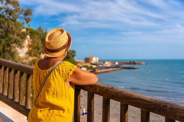 Starsza pani patrząca na morską plażę La Caleta w Cabo Roig Alicante senior travel