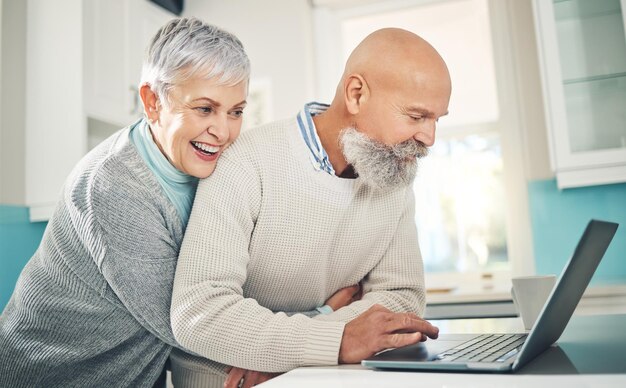 Starsza para laptopów i uściski w domu, przeglądanie Internetu i media społecznościowe w domu Emerytura komputerowa i szczęśliwy mężczyzna i kobieta obejmują się podczas czytania wiadomości e-mail lub wspólnego przesyłania strumieniowego śmiesznego wideo