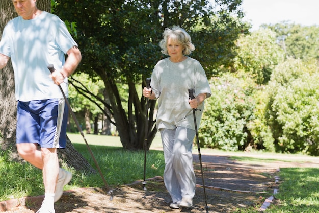 Starsza para Nordic walking w parku