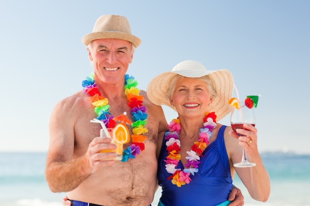 Starsza para pije koktajl na plaży