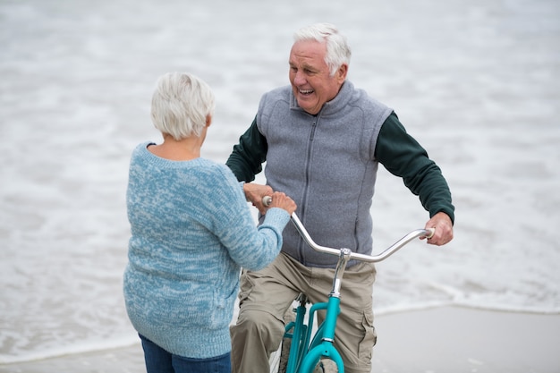 Starsza pary pozycja z bicyklami na plaży