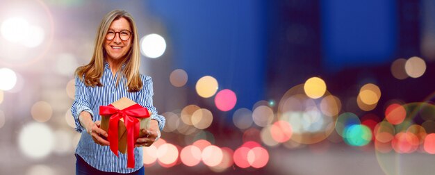 Starsza piękna kobieta z prezenta pudełka pojęciem