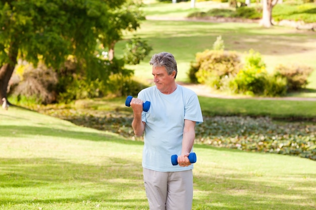 Starsze osoby obsługują robić jego ćwiczeniom w parku