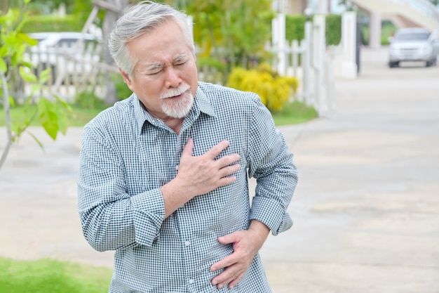 Starszy Azjatycki Człowiek O Bolesnym Zawale Serca W Klatce Piersiowej W Parku Na świeżym Powietrzu - Koncepcja Choroby Serca.