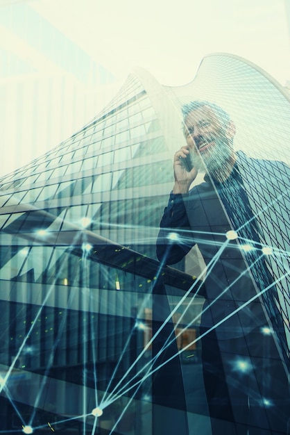 Zdjęcie starszy biznesmen korzystający z efektu podwójnej ekspozycji telefonu komórkowego