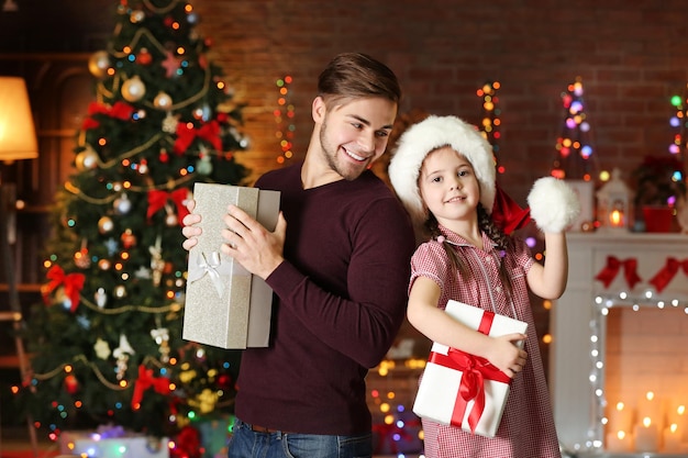 Starszy brat i młodsza siostra w Santa hat z prezentem na Boże Narodzenie tle