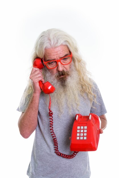 Starszy Brodaty Mężczyzna Myśli I Patrzy W Dół Podczas Rozmowy Na Starym Telefonie