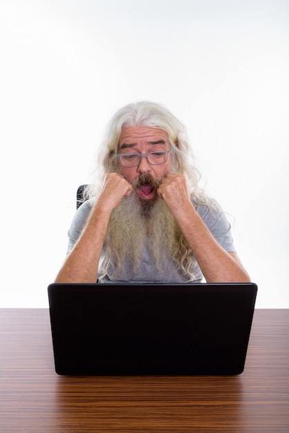 starszy brodaty mężczyzna w okularach podczas korzystania z laptopa
