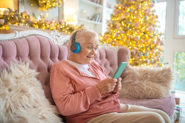 Starszy kobieta, słuchanie muzyki w słuchawkach