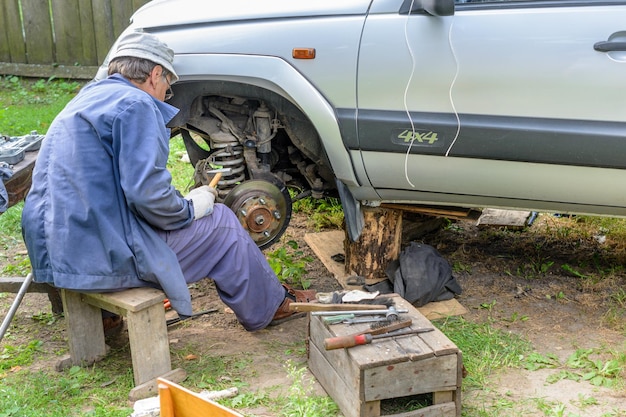 Starszy mechanik naprawiający przednie koła w piaście