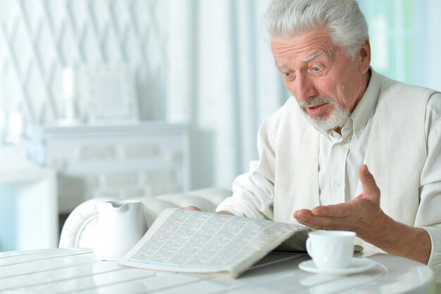 Starszy mężczyzna czyta gazetę