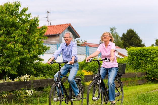 Starszy Mężczyzna I Kobieta ćwiczeń Z Rowerami Na Zewnątrz, Są Parą