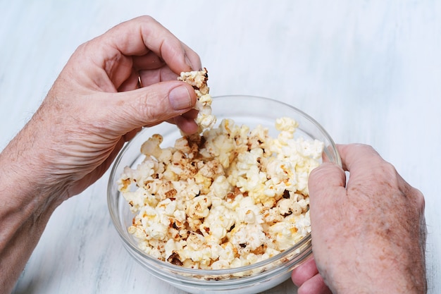 Starszy mężczyzna jedzenie popcornu