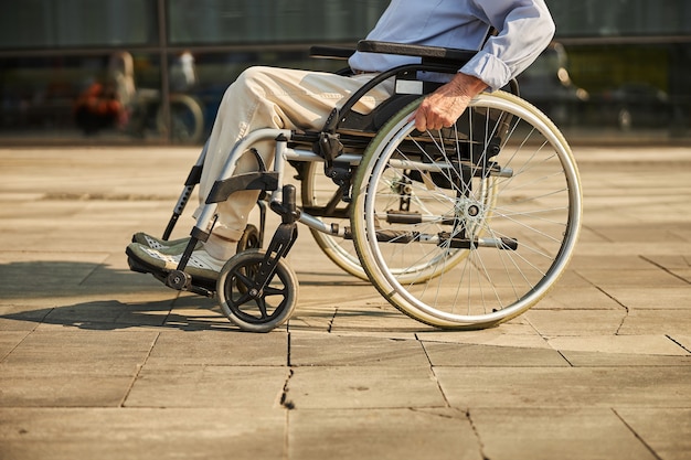 Starszy mężczyzna na wózku inwalidzkim w mieście