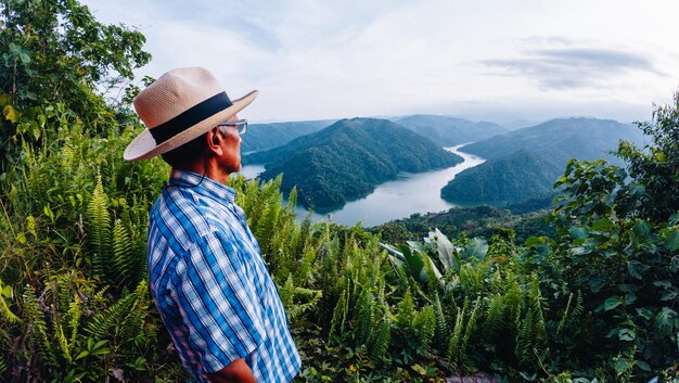 starszy mężczyzna patrząc na krajobraz rzeki i gór na wakacjach