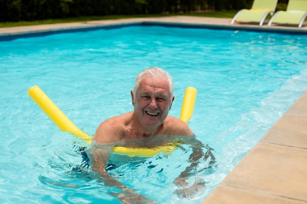 Starszy mężczyzna pływanie z nadmuchiwaną rurką w basenie