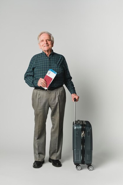 Starszy Mężczyzna Podróżujący Z Biletem Lotniczym I Paszportem Przewożącym Bagaż