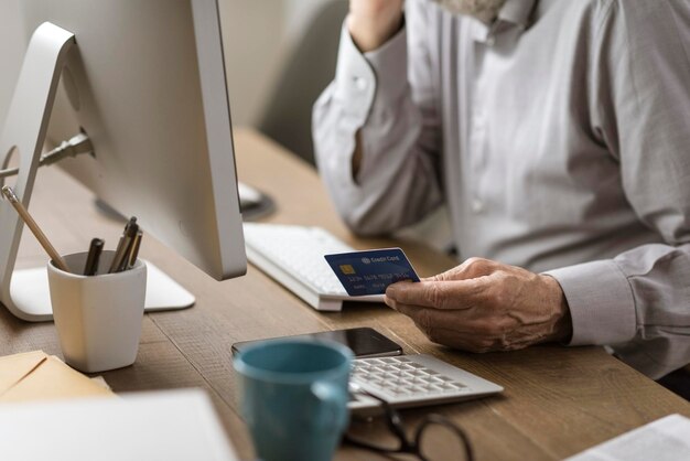 Starszy mężczyzna robi zakupy online za pomocą karty kredytowej