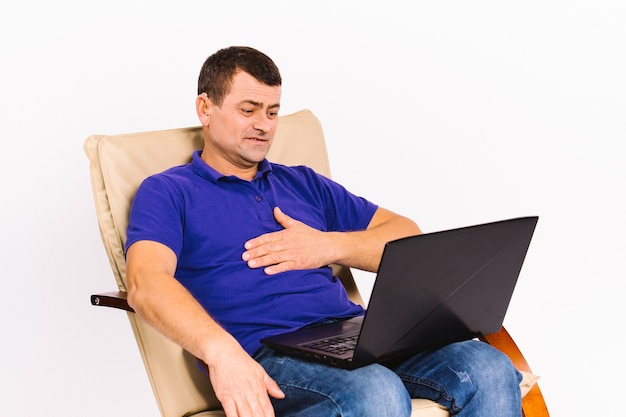 Starszy mężczyzna siedzący na krześle komunikuje się w języku niewerbalnym za pośrednictwem komunikacji wideo na laptopie