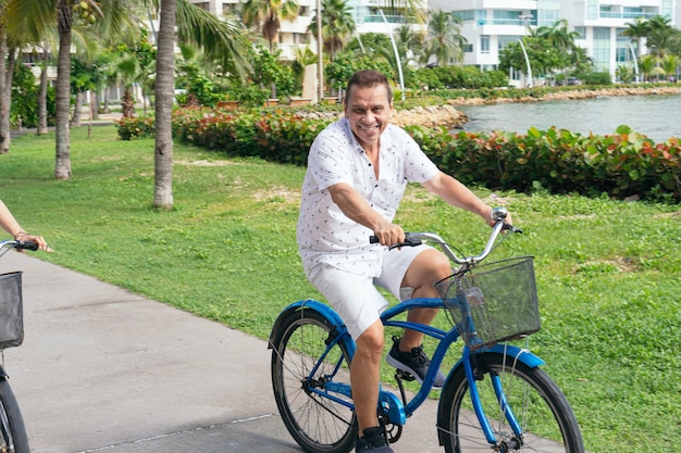 Starszy mężczyzna spędzający wolny czas na rowerze po mieście
