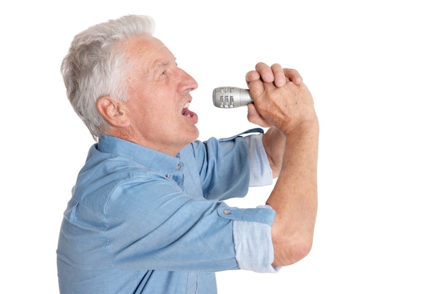 Starszy mężczyzna śpiewa do mikrofonu na białym tle