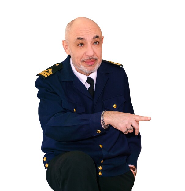 Starszy mężczyzna w mundurze morskim wskazuje palcem na coś na białym tle