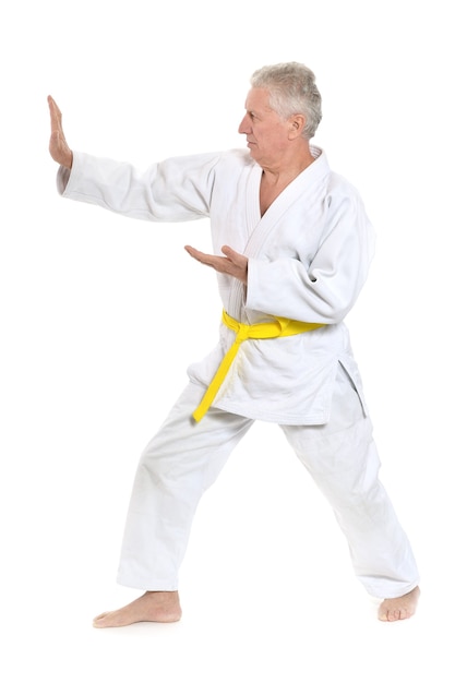 Starszy mężczyzna w pozie karate na białym tle