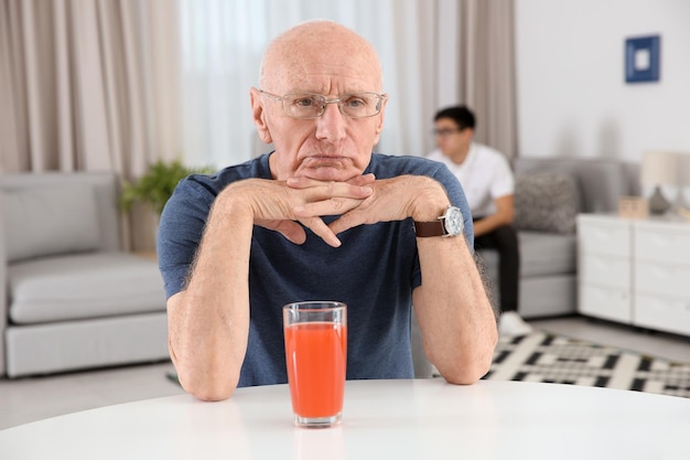 Zdjęcie starszy mężczyzna ze szklanką soku w domu opieka nad osobami starszymi