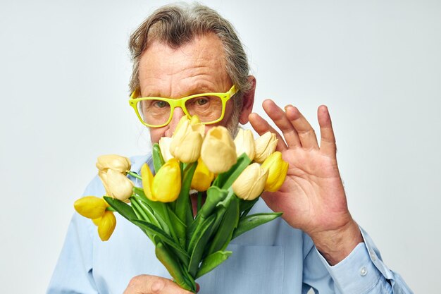 Starszy mężczyzna żółty bukiet kwiatów stwarzających jasne tło