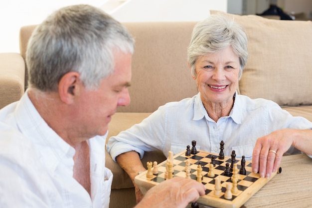 Starszy para siedzi na podłodze gra w szachy