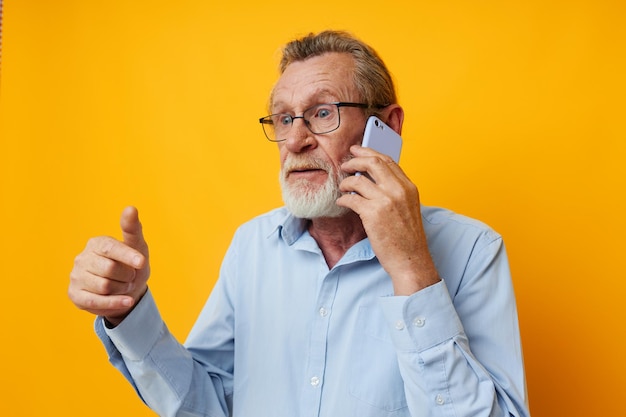 Starszy siwy mężczyzna rozmawia przez telefon emocje na białym tle