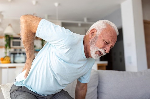 Starszy starszy mężczyzna dotykając pleców cierpiących na ból pleców rwa kulszowa siedzący tryb życia koncepcja kręgosłupa problemy zdrowotne ubezpieczenie zdrowotne