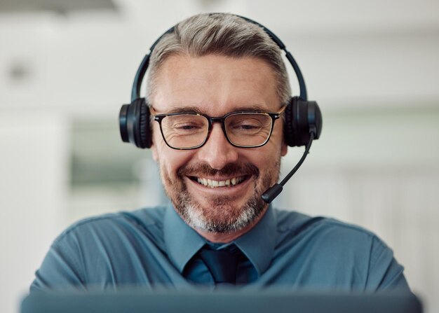 Starszy Szczęśliwy Mężczyzna I Call Center Ze Słuchawkami W Telemarketingowej Obsłudze Klienta Lub Wsparciu W Biurze Dojrzały Konsultant Biznesmen Lub Agent Uśmiecha Się, Udzielając Porad Online Lub Kontaktując Się Z Nami W Miejscu Pracy