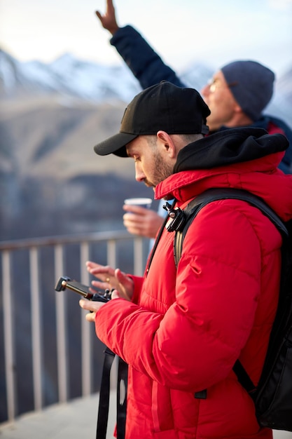 Start drona w górach turysta steruje dronem z pilota za pomocą smartfona...