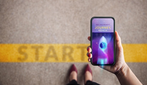 Start Koncepcje Startup Rozpocznij nowy biznes Kobieta stojąca na linii startu podczas korzystania z telefonu komórkowego do odliczania nowej podróży Widok z góry