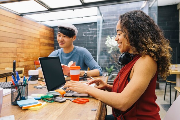 Startup Dwóch Wieloetnicznych Osób Radośnie Dyskutujących O Pomysłach W Nowoczesnej Przestrzeni Coworkingowej