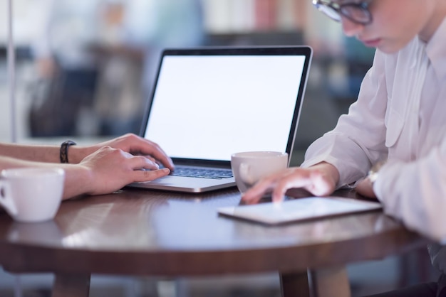 startupowcy korzystający z laptopa przygotowujący się do kolejnego spotkania przy kawie i omawiający pomysły w kreatywnym biurze