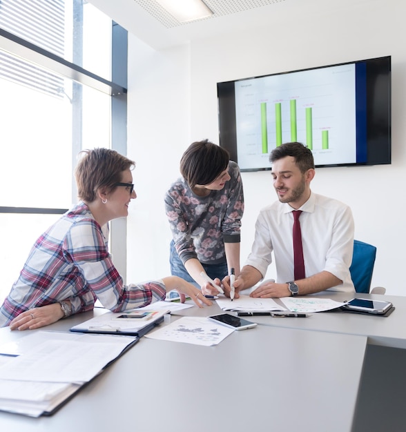 startupowy biznes, młodzi kreatywni ludzie grupują się w burzę mózgów podczas spotkania we wnętrzu biura i używają laptopa i tabletu do notowania pomysłów, planów i projektów